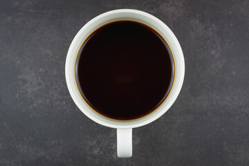 Black coffee in white cup, on dark background.