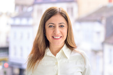 Happy friendly middle-aged businesswoman in a city office