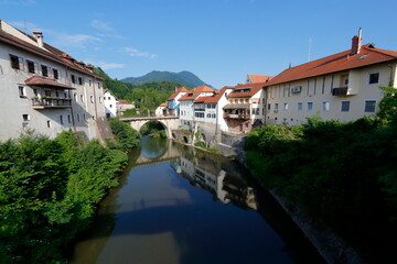 Fototapeta na wymiar river run across the city of Skofja-Loka, Slovenia. Old walled city