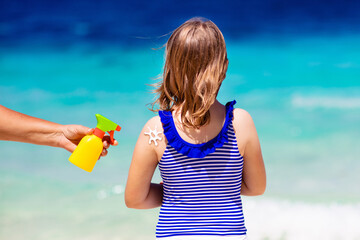 Mom applying sunscreen on child. Safe beach fun.