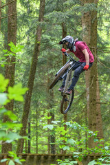 Spektakulärer Mountainbiker springt gekonnt über eine Rampe im Wald
