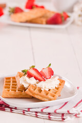 Waffles with strawberries and whipped cream.