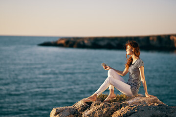 woman in the mountains sits on the seashore nature landscape