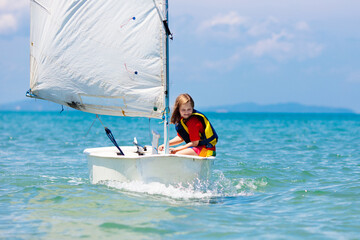 Child sailing. Kid learning to sail on sea yacht.