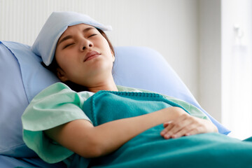 An asian young beautiful female patient getting sick, lying and sleeping on bed in hospital with...