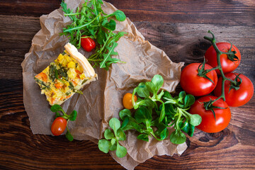 Fresh vegetable casserole with salad served on a rustic wooden board