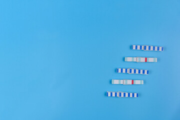 Wooden clothespins on a blue background. View from above