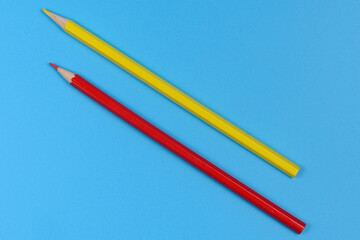 Red and yellow pencil on blue background