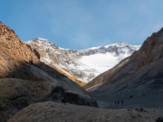 Climbing tourists to the Mutnovsky volcano. Group of tourists goes along the mountain track to reach the top of the volcano. Kamchatka Peninsula, Russia.