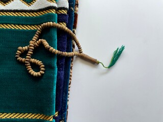 prayer beads and prayer mats on white background