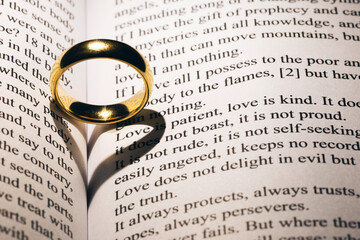Golden wedding ring on bible book - Powered by Adobe