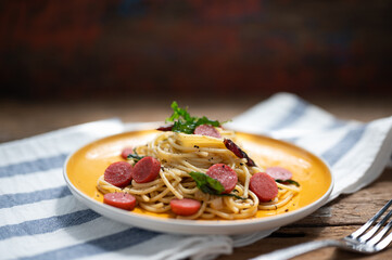 Spaghetti spicy with sausage in yellow dish