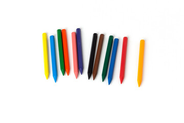 New children's colored wax crayons on a white sheet of paper close-up. Drawing as a hobby and developing creativity