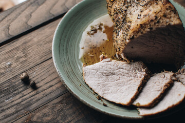 Roasted pork tenderloin, juicy and succulent oven-baked piece of meat rubbed with mustard and spices. A juicy piece of baked meat.