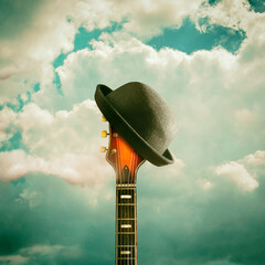 Old electric guitar, hat, in the cloudy sky. Background for festivals, concerts.Copy space.Toned....