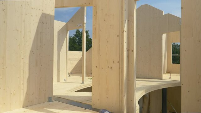 CLOSE UP: Beautiful hardwood real estate project is erected in the countryside. Glued-laminated timber house is being built in countryside. Aluminum ladders lie around the CLT house under construction