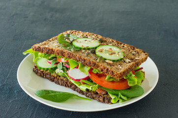 Homemade healthy wholegrain sandwiches with vegetables and smoked salmon. Tasty breakfast and healthy eating concept