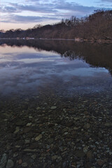 透き通った水に夜明けの空が映る朝の湖。