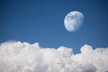 Low angle view of the moon in the waning gibbous phase on a blue cloudy sky