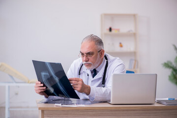 Old male doctor radiologist working in the clinic