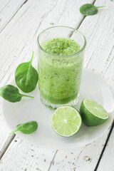 Healthy lifestyle. Celery, spinach and lime smoothie. Drink glass, lime, spinach leaves.