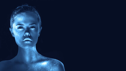 Creative portrait of girl with glowing skin, blue tone in dark