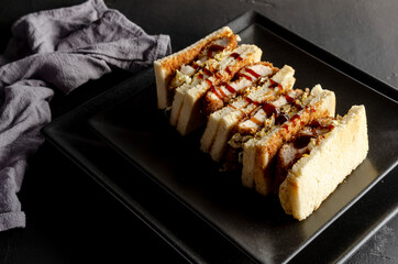 Katsu sandos japanese sandwich with chicken or pork chop, cabbage and tonkatsu sauce.