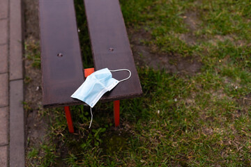 blue antiviral mask against coronavirus lies on a bench