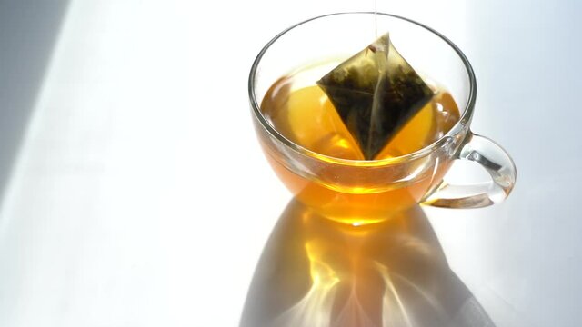 Green Morning Tea. Tea Triangle Bag in a Teacup. Brew Green Tea in a Mug. Close-Up. View from above