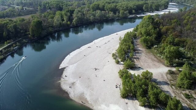 Italy , Pavia Torre Isola, Milan  - Drone aerial view of Ticino natural reserve river with people in the beach after Covid-19 Coronavirus lockdown quarantine home - Lombardy Po Valley and trees forest