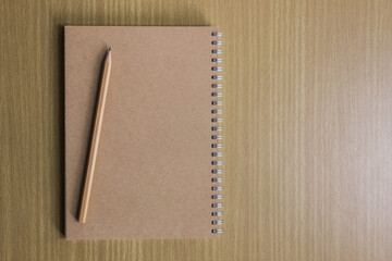 Notebook with pencil on a wooden table.