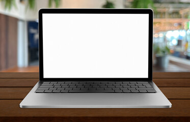 Blank screen laptop computer on wood table top with coffee shop bokeh background.