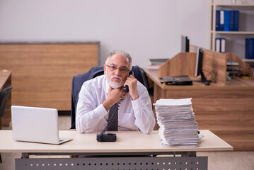 Old male employee unhappy with excessive work in the office