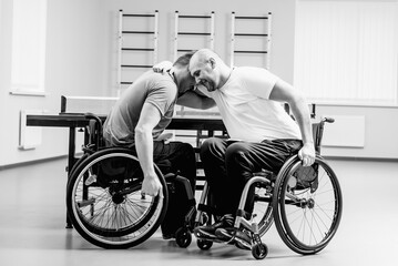 Adult disabled men hugs after playing table tennis