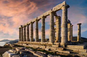 Sounion, Attica - Greece. The Temple of Poseidon at cape Sounion. Colorful sunset with beautiful cloudy sky. Golden hour