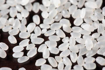 Obraz na płótnie Canvas Close-up raw white grains of rice on wood background