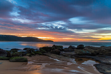 Fototapeta na wymiar Sunrise at the seaside with pastel coloured clouds