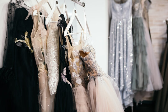 Beautiful collection wedding dresses various colors hanging on a hanger in a clothing store shop shopping mall. Fashion fancy stylish exhibition. Image with copy space.