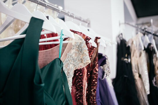 Beautiful collection wedding dresses various colors hanging on a hanger in a clothing store shop shopping mall. Fashion fancy stylish exhibition. Image with copy space.