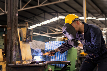 Factory technicians are welding young.  Metal welding steel works using electric arc welding...