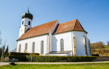 Fototapeta na wymiar White church St. Stephanus at Poltringen, Ammerbuch near Tuebingen, Baden-Wuerttemberg, Germany, with blue sky in spring