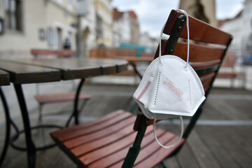 Corona crisis - lockdown - FFP2 mask hangs on a chair in an empty beer garden in Steyr, Austria, Europe