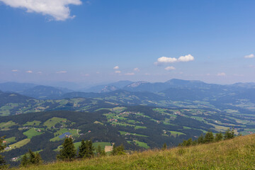 Fototapeta na wymiar Sunny day in Alpine mountain fields with panoramic view to valley, Austria