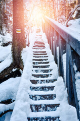 In winter, snow-covered stairs lead to the summit in the Stolowe Mountains on a hiking trail.