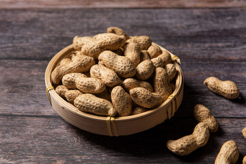 Raw fresh peanuts on wood background