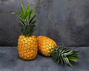 Two 2 Pineapples on a black stone table. Tropical Fruits.