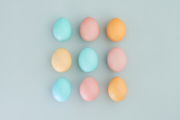 Painted eggs in pastel colors on a blue background. Easter concept. Top view, flat lay