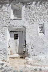 Fototapeta na wymiar door and windows of old whitewashed farmyard in white color