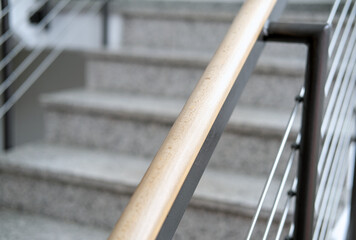 Nahaufnahme eines Handlaufs aus Holz und Stahl, Detail einer modernen Treppe in einem neuen...