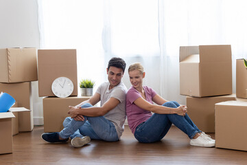 Caucasian couple sit on with stuff in boxes moving to new home